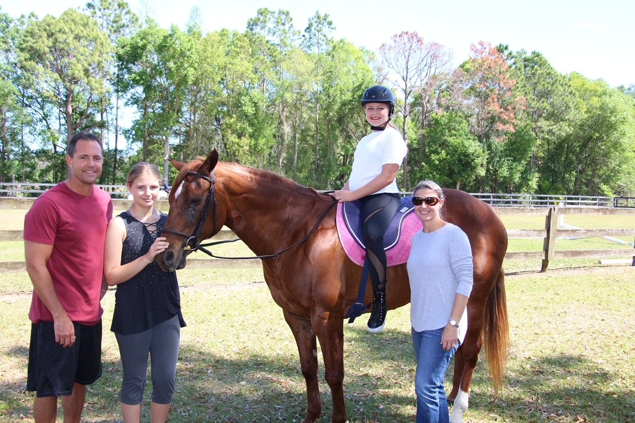 A child grooming a horse at summer horse camp